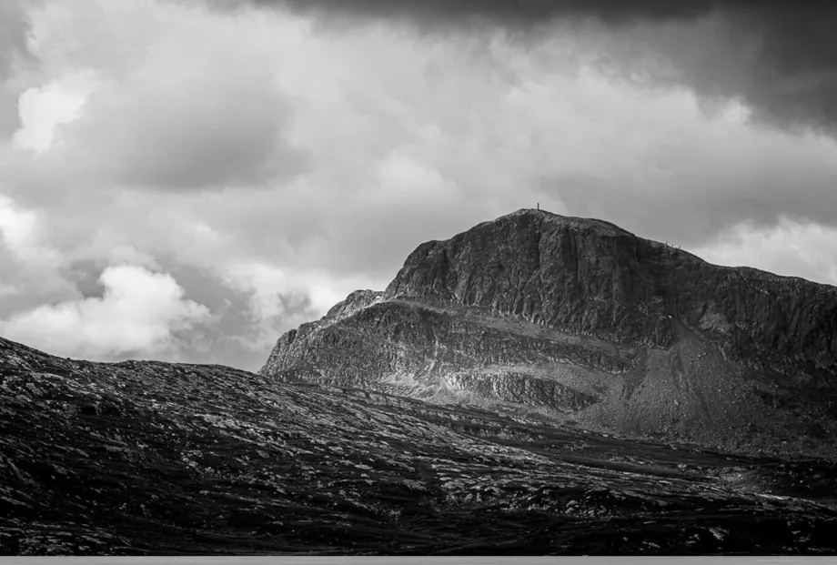 Fjelltopp under mørke skyer
